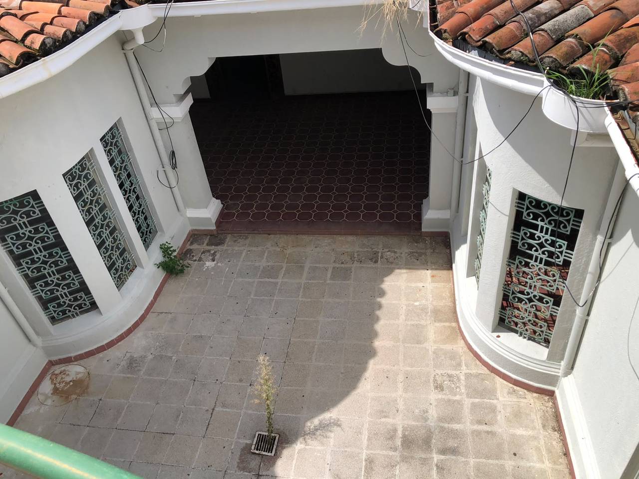 Antes: arco abierto y maleza en el patio